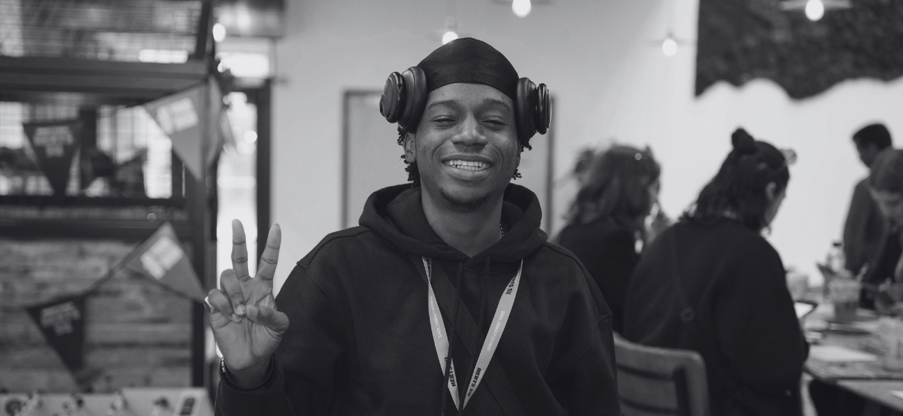 Student smiling at the camera and displaying the 'peace' sign