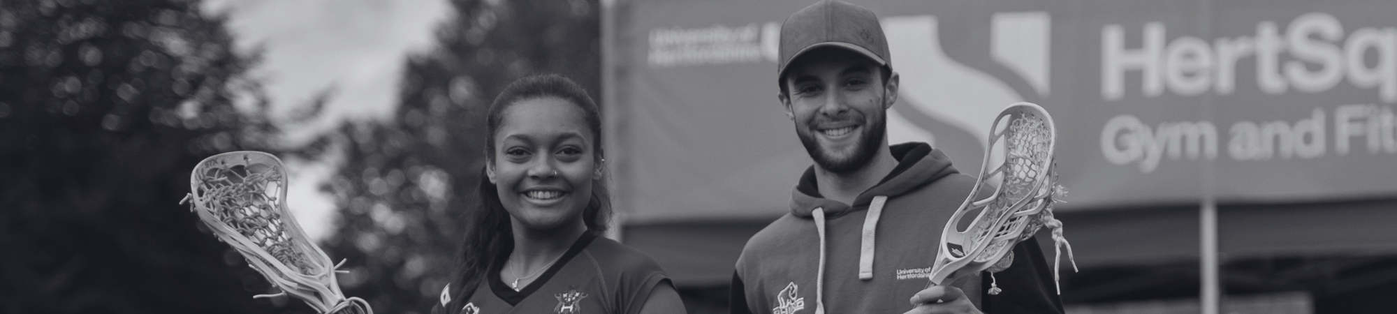 Students smiling holding squash sticks