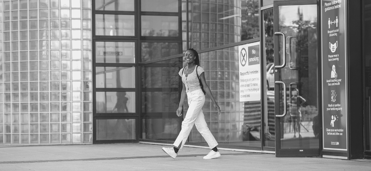 Student walking out of the library on campus