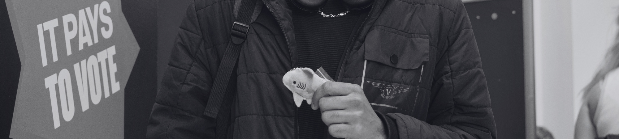 Student holding a mini Sharkie plushie