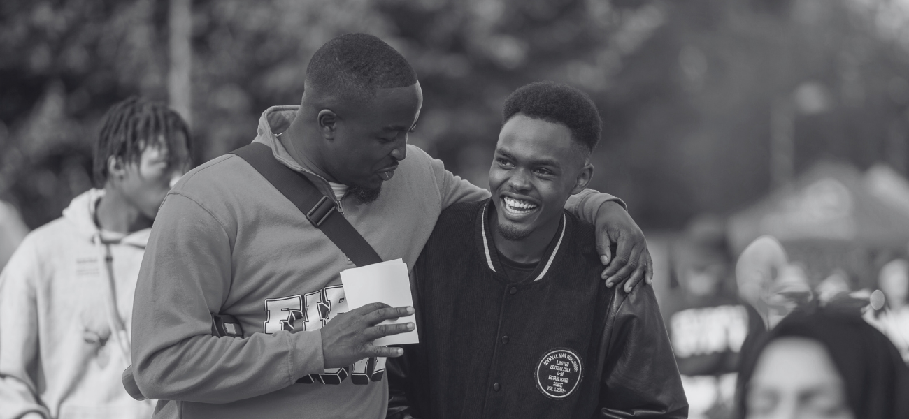 Two students embracing and giggling on campus
