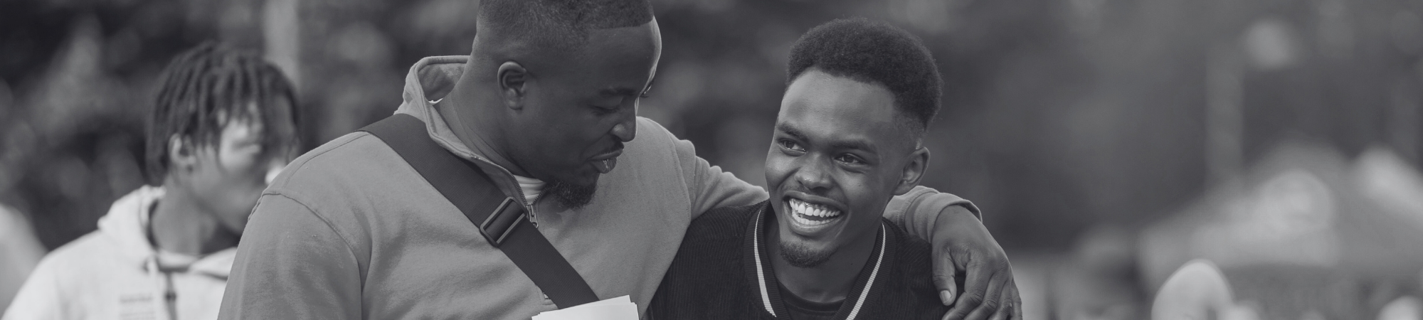 Two students embracing and giggling on campus