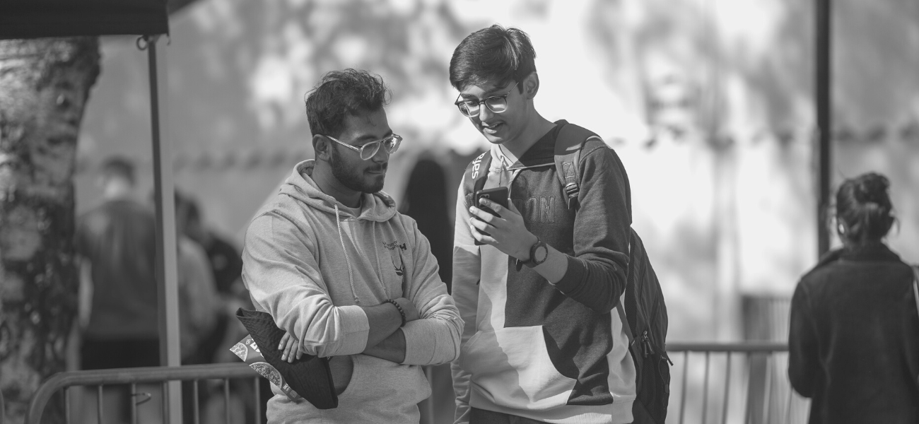 Students looking at a phone during Freshers Fair