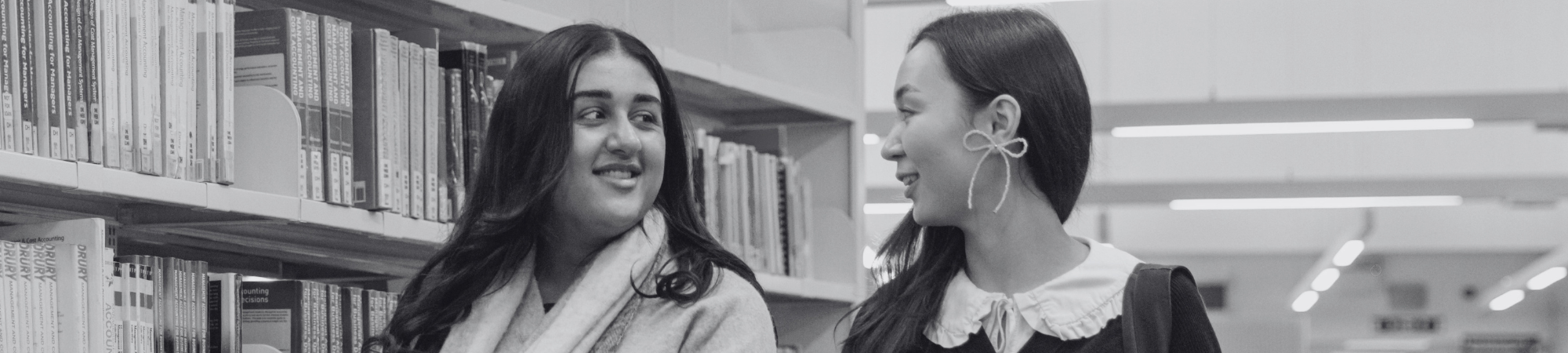 Two students walking in a library