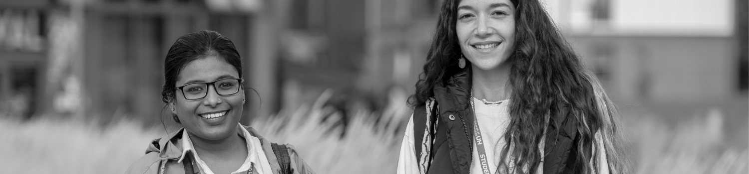 Picture of two students on campus, smiling at the camera