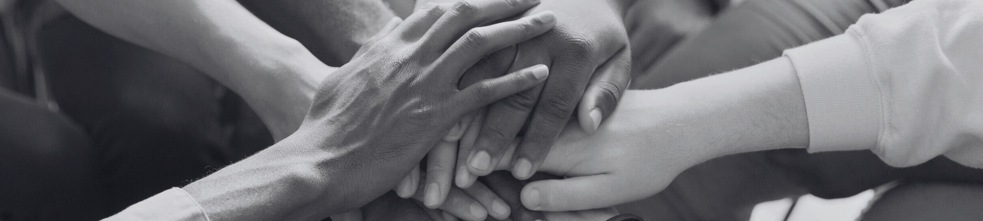 Hands compiled on top of one another in a sign of unity