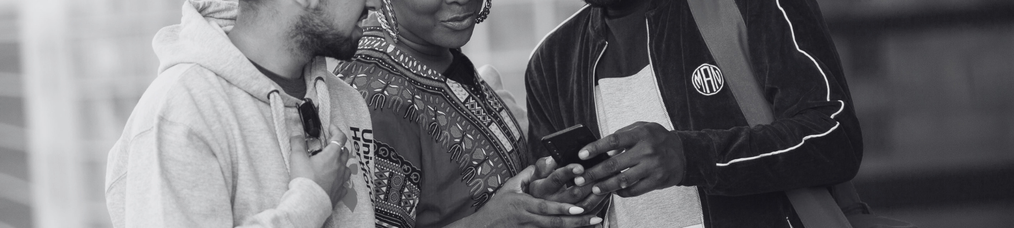 Three students looking at a phone