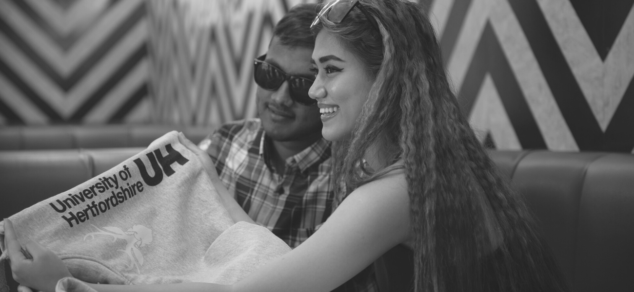 Students admiring their University of Hertfordshire hoodie