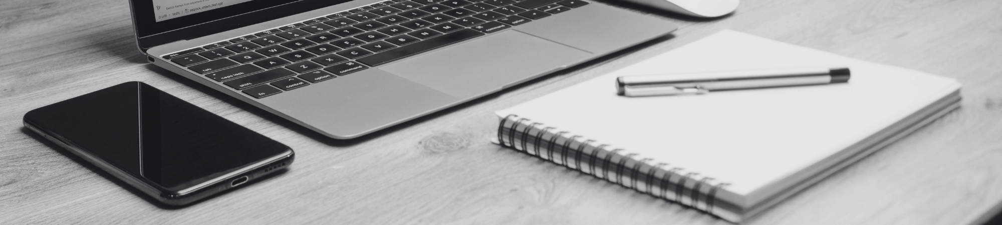 Laptop, phone and a notepad on a desk